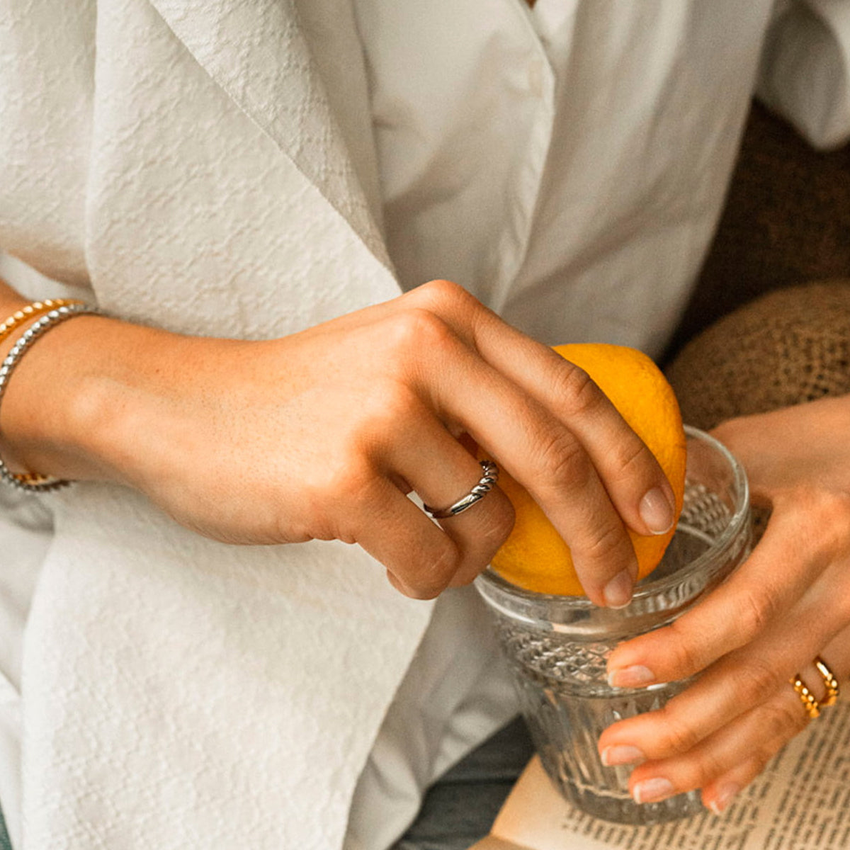 Person wearing AN JEWELS JEWELRY Mod. AAC.R05S-8 ring squeezing lemon into glass