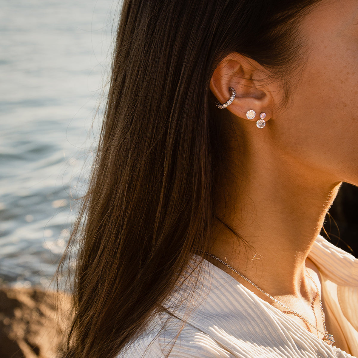 Woman wearing AN JEWELS JEWELRY Mod. AL.NLFY01 earrings by the ocean.