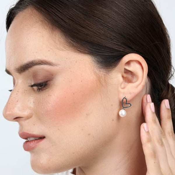 Woman wearing LA PETITE STORY JEWELRY Mod. LPS02AQM24 earring with heart and pearl detail