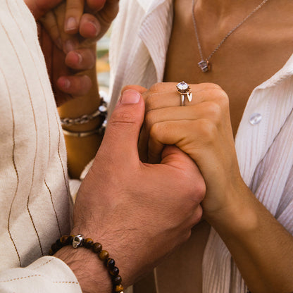 Couple holding hands showcasing jewelry, featuring AN JEWELS JEWELRY Mod. AL.NLFY01 ring and necklace.