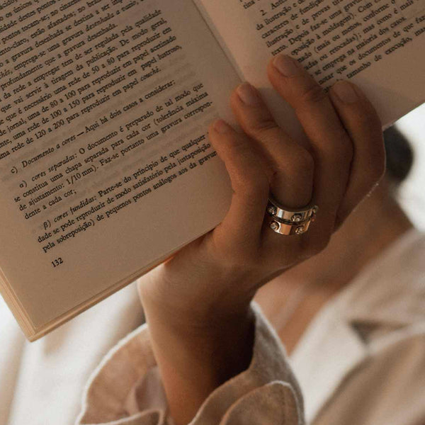 Person wearing AN JEWELS JEWELRY Mod. AL.RWH01SC-8 ring while holding a book, showcasing elegant design and style.