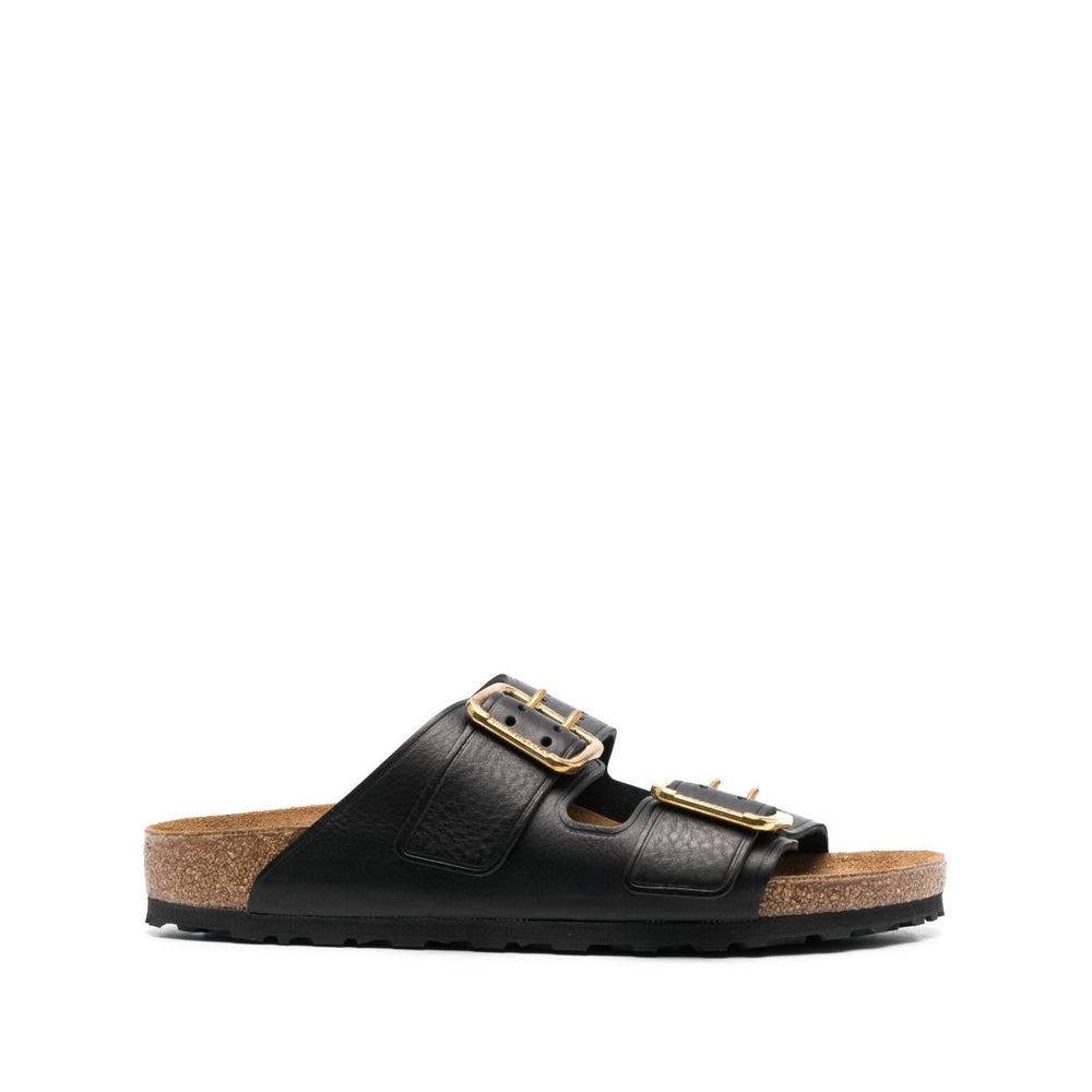 Birkenstock Double-strap leather sandals with black leather and gold-tone hardware, featuring logo-engraved buckles and flat rubber sole.
