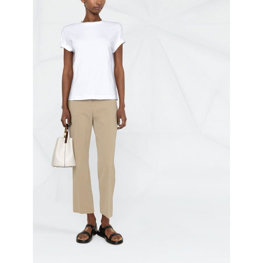 Model wearing Brunello Cucinelli Chain-trim round-neck t-shirt in white with short sleeves and chain-link detailing, styled with beige pants.