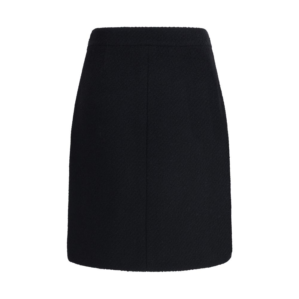 Chloé Black Wool Midi Skirt with bouclé texture, knee-length design, front flap pockets with gold buttons, and side zip fastening, AW25.