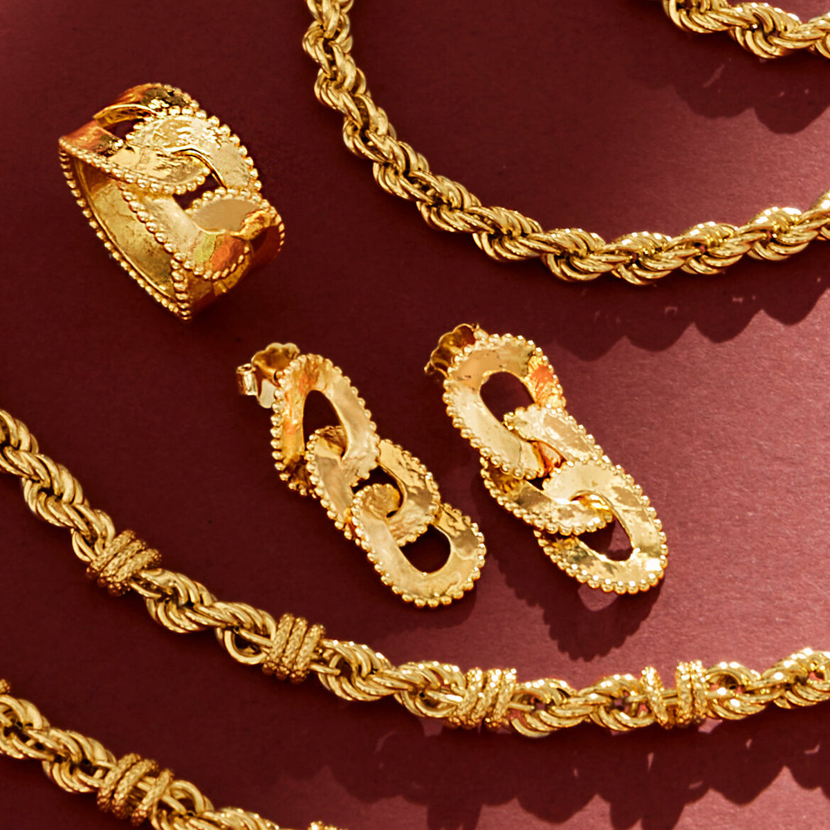 Gold jewelry set featuring ETRUSCA JEWELS JEWELRY Mod. WSET00672.YG - 16 with necklaces, earrings, and ring on a red background.