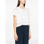Side view of model wearing white Emporio Armani T-shirt with fringes, crew neck, short sleeves, and embroidered logo, styled with black pants.