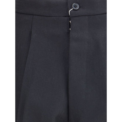 Close-up of Margiela Black Wool Dress Pants showcasing pleated design and button closure.