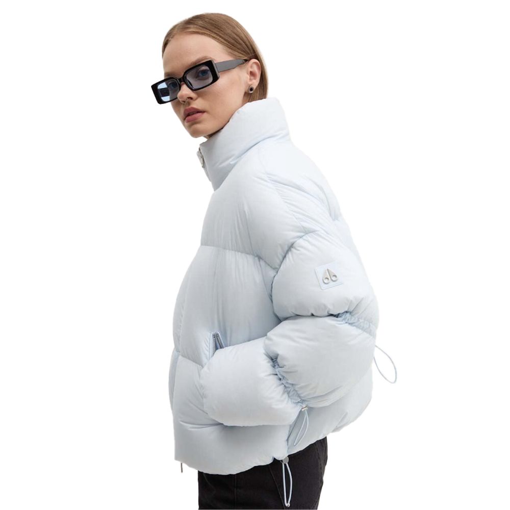 Woman wearing Moose Knuckles Light Blue Nylon Women Jacket with down padding, styled for chic outdoor looks, featuring sleek sunglasses.