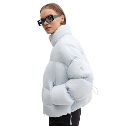 Woman wearing Moose Knuckles Light Blue Nylon Women Jacket with down padding, styled for chic outdoor looks, featuring sleek sunglasses.