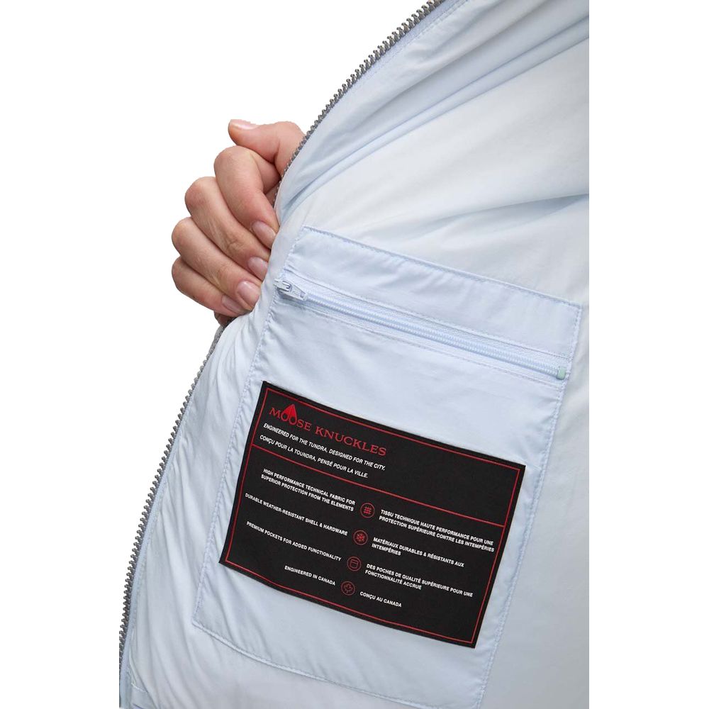 Interior label of Moose Knuckles Light Blue Nylon Women Jacket showcasing care instructions and pocket details.