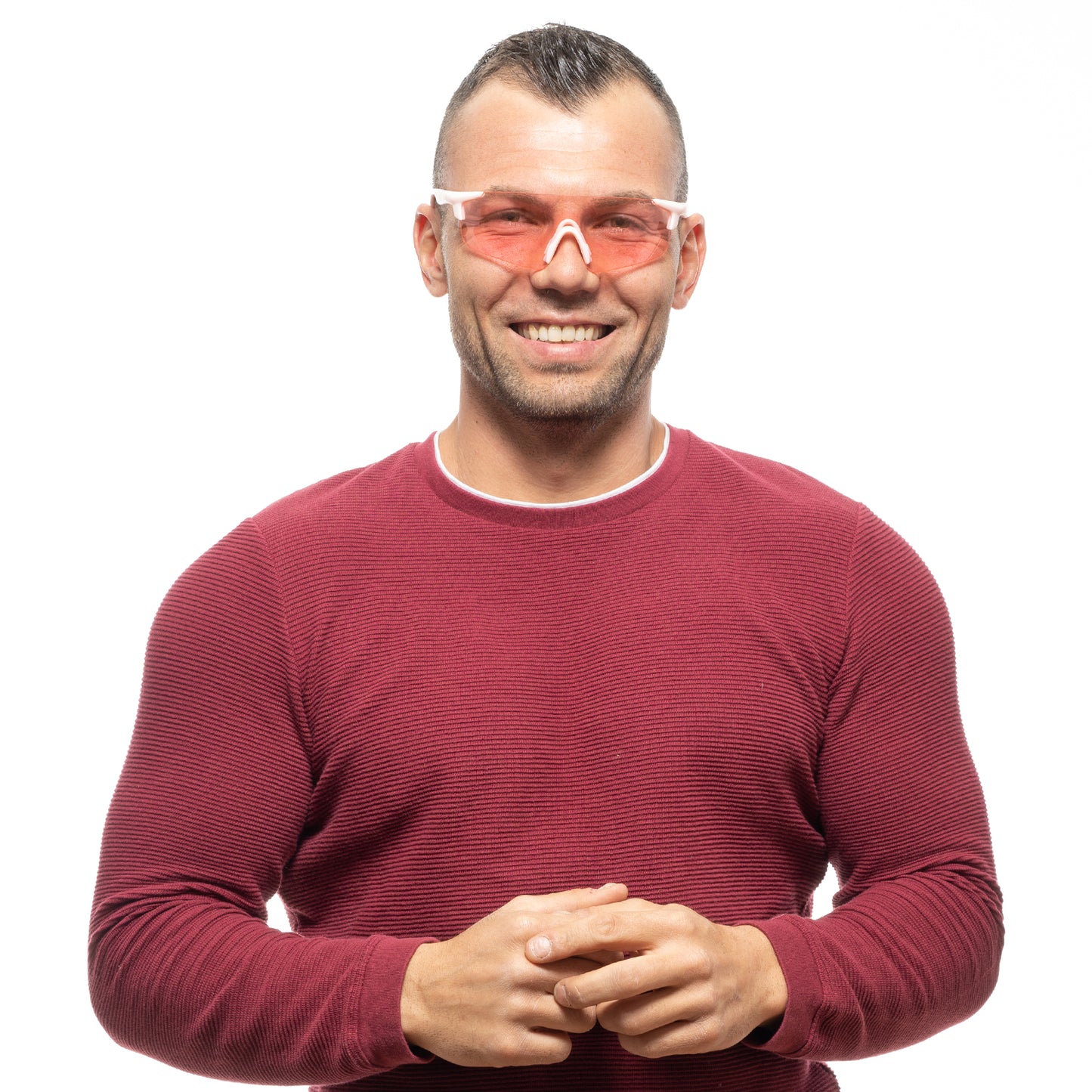 Man wearing red sweater and stylish sunglasses smiling at the camera