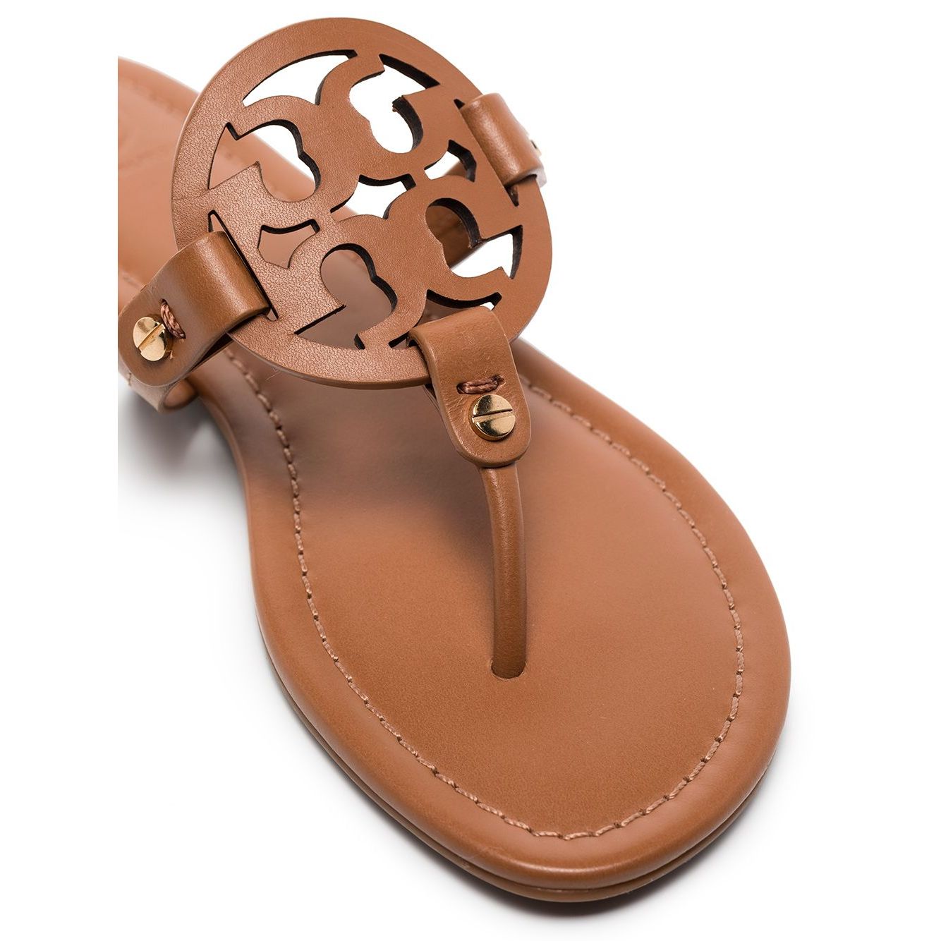 Close-up of brown leather Tory Burch Miller Sandals with laser-cut Double T logo and thong strap.